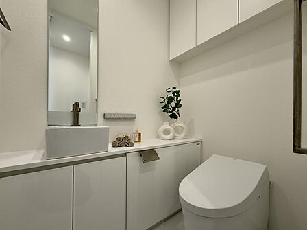 手洗い場・鏡付きのトイレで、収納スペースも豊富なため掃除用品などをすっきりまとめられます。