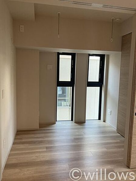 落ち着いた木目調のフローリングが広がる、心地よい寝室。窓から柔らかな光が差し込み、穏やかな朝を迎えられます。自分好みの家具を置いて、ゆとりのあるプライベート空間を演出できます。
