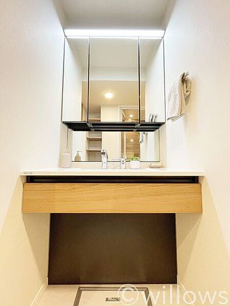 大きな三面鏡を備えた、スタイリッシュな洗面化粧台です。ちらかることなく鏡裏などの豊富な収納スペースにより、毎日の身支度が快適に行えます。ライトはセンサーのため、手が濡れていても接触せずにつけられます。