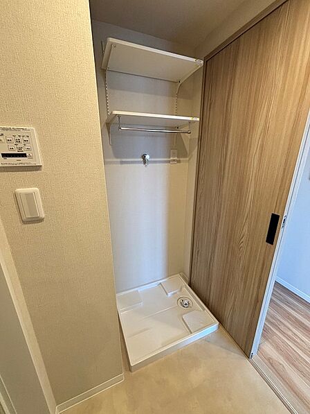洗濯機置き場も広々、タオル掛けや棚が便利です。
