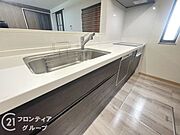 白を基調とした清潔感ある対面式キッチンとリビングとの一体感が魅力。収納も豊富で日々の調理がスムーズに。IHコンロやスライド収納など機能面も充実しており、使いやすさとデザイン性を兼ね備えています。