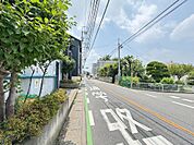本マンションの目の前の道路。車通りや人通りもある程度あるので防犯面でも安心できると思います。