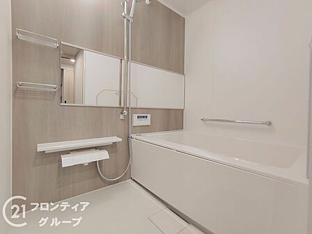 木目調のアクセントパネルが落ち着いた雰囲気を演出する、ゆったりとしたバスルームです。一日の疲れを癒すプライベートな空間として、心ゆくまでリラックスした時間をお過ごしいただけます