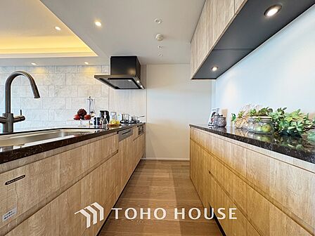 【Kitchen】美しく使いやすいキッチンは油汚れが簡単に拭き取れる素材で加工されており、浄水器シャワーから流す水の音を軽減する静かなシンクを採用。見えないところにさり気ない配慮が嬉しい