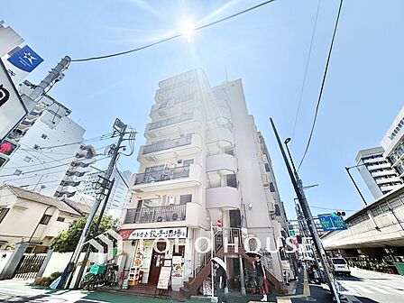 青空に映えるすっきりとした外観。1階には飲食店が入っており、周辺には銀行なども揃う生活利便性の高い立地環境です。