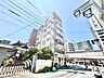 外観：角地に立ち、青空に映えるすっきりとした外観。道路沿いで視認性も良く、ゲストを招く際にも分かりやすい立地です。