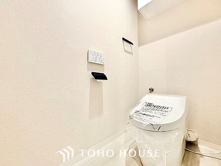 空間を広々と見せるタンクレスデザインを採用。上部にはトイレットペーパーなどを隠して収納できる便利な吊戸棚を備え、清潔感と洗練された雰囲気を両立した快適なレストルームです。