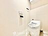 トイレ：空間を広々と見せるタンクレスデザインを採用。上部にはトイレットペーパーなどを隠して収納できる便利な吊戸棚を備え、清潔感と洗練された雰囲気を両立した快適なレストルームです。