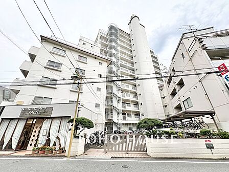 白を基調とした爽やかな外観デザイン。13階建ての存在感あるフォルムで、1階店舗部分や植栽の手入れも行き届いた管理体制の良さが伺えます。