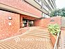 外観：広々としたアプローチは段差の少ない設計。植栽の緑とあたたかみのあるレンガが住まう人を優しく迎え入れます。