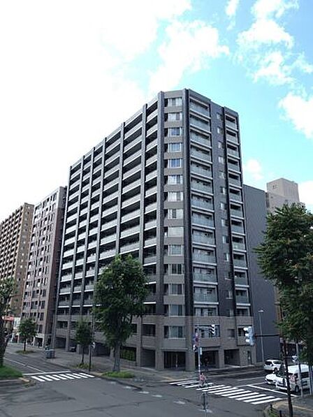 《外観写真》青空が映える15階建てマンション。アクセス良好で暮らしに便利な立地です。