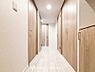 室内：上質感漂う廊下。居住者の帰り、訪れる方を優しく迎え安らぎに満ちた生活空間を予感させます。