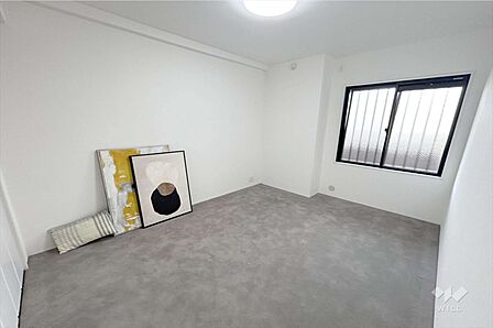 洋室約5.8帖。窓が開けられているため、日当たりが良好で快適です。グレーとホワイトの配色が上品な、清潔感のある空間。