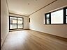 寝室：木目のフローリングが暖かみのある室内に。明るい寝室で心地のいい朝を迎えられそう。