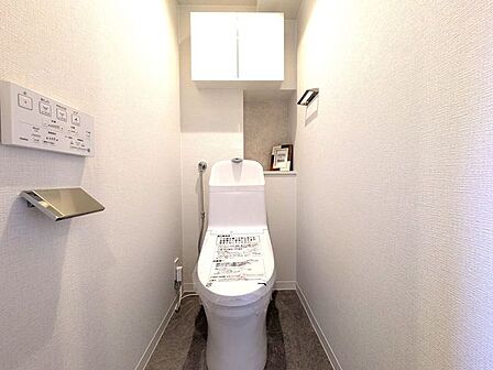 ■温水洗浄便座付きトイレ■白を基調とした内装に、アクセントとなる床材で落ち着いた空間に仕上がっています。上部にはトイレットペーパーなどのストックをスッキリ隠して収納できる、扉付きの棚があります◎