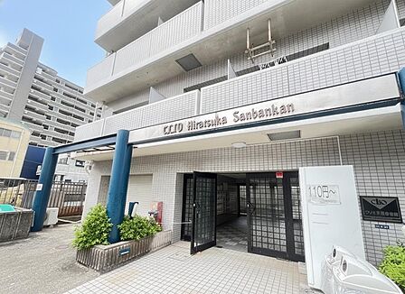 【エントランス】エントランス入口には屋根がありますので、雨の日も慌てずに傘をさすことができます。飲料水の自動販売機が設置されています。お出かけの際に、気軽に購入することができ、便利です。