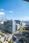 バルコニーからの眺望（東）街並みの奥に広がる空と水辺の景色を、室内から穏やかに楽しめます。