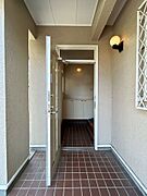 【リフォーム中】玄関のお写真です。屋根がついておりますので、雨にも濡れることなく準備ができるのは安心ですね。玄関が道路に面していないので、お子様が急に飛び出しても安心ですね。