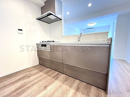 シンプルなお部屋の雰囲気に溶け合うナチュラルなシステムキッチンです