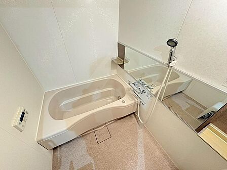 【浴室】淡い色合いでまとめられた清潔感のある浴室。足を伸ばして、1日の疲れをゆったりと癒やしていただけます。ワイドミラーが備わっており、湯船に浸かりながらフェイスケアが行えます。