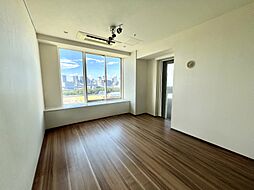 ワイドな窓から都心の景色を一望できるリビング。柔らかな自然光が室内を包み込み、上質で開放的な空間を演出します。