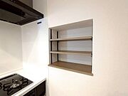 キッチンコンロ横付近に調味料や備品が収納出来る埋め込み式の棚がございます。