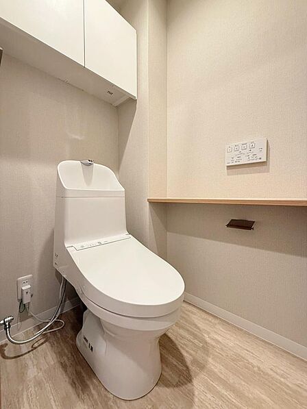 清潔感のある温水洗浄便座付きトイレ!快適な使用感はもちろん、上部にはトイレットペーパーや掃除用品をスッキリ整理できる便利な収納棚を備えています。