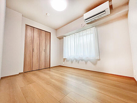 大きな窓からたっぷりと陽光が注がれる明るい空間。一日の疲れをいやしてくれる主寝室。時を忘れて過ごす場所として過ごせるお部屋。木目のフローリングが暖かみのある空間に演出します。