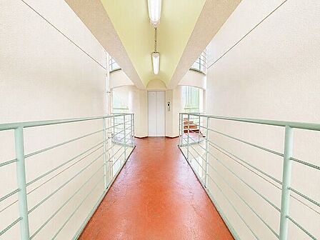 共用廊下：赤茶色の光沢のある床と白い壁でホテルを感じさせます。※実際の写真をもとにCG加工をしています。