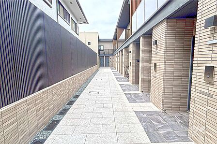 住戸までのアプローチ。質感豊かなタイル素材を採用。玄関までフラットなためお荷物やベビーカーを運ぶのに便利です。