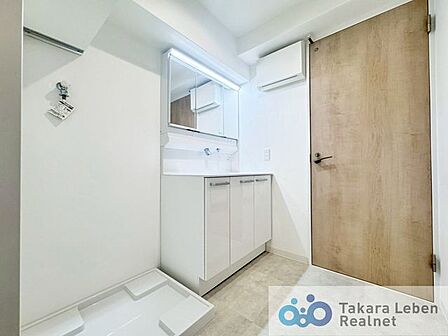 洗面台の横には、防水パン付きの洗濯機置き場があり、家事動線に配慮した配置になっています。