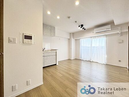 ナチュラルな木目調の床から木のぬくもりを感じられる広々としたリビングルーム。