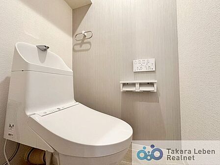 ウォシュレット機能付きのトイレは壁掛けリモコンの上位グレードを採用。便座がスッキリした印象となり、限られた空間を広く見せる効果があります。