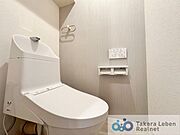 ウォシュレット機能付きのトイレは壁掛けリモコンの上位グレードを採用。便座がスッキリした印象となり、限られた空間を広く見せる効果があります。