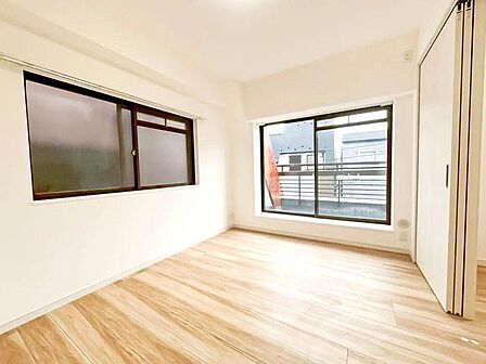 やさしい陽射しが差し込む寝室は、心地よい眠りへと誘う癒しの空間。木目調の床と白を基調とした壁が、清潔感とやわらかな印象を与え、毎日の疲れをそっと包み込みます。