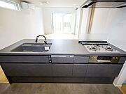 対面式のシステムキッチンで、家族の顔を見ながら料理できる開放的な空間です。※現況の物件写真に、引渡し時のイメージとして CG による画像処理がされています。