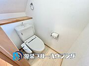 【温水洗浄便座付きのトイレ空間】階段下のスペースを有効活用したトイレ。手洗い付きのタンクを採用し、木目調のペーパーホルダーを設置。
