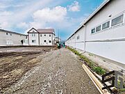 広々とした前面道路に面し、車の出し入れがしやすい現地外観。ゆとりある駐車スペースと開放感のある立地が魅力で、毎日の暮らしに快適さと安心をもたらすマイホームです。