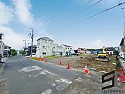 広々とした前面道路に面し、車の出し入れがしやすい現地外観。ゆとりある駐車スペースと開放感のある立地が魅力で、毎日の暮らしに快適さと安心をもたらすマイホームです。