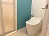 トイレ：清涼感のあるエメラルドグリーンをアクセントクロスにしました。タンクレスのトイレを設置