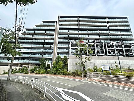 広大な敷地に北棟・南棟の2棟を配置。洗練されたフォルムとガラス手摺が青葉の丘に映え、階段状デザインも印象的。アプローチには高木・低木を組み合わせた植栽で、四季折々の花木が潤いを演出します。
