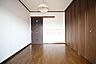 寝室：木目調の建具と大きなクローゼットを備えた5.5帖の洋室