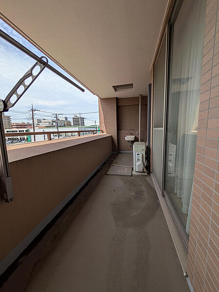物干し金物とスロップシンクを備えたバルコニーです。目の前に高い建物がなく開放感があり、ご家族分のお洗濯物もゆったりと干していただけます。※AIによる家具配置加工を行なっております。