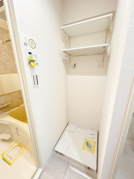 洗濯機置場。上部には吊戸棚があり、消耗品を収納でき