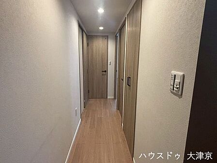 ダウンライトが導く上質な動線。洗練された木目調が彩る廊下。
