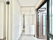 【リフォーム後　玄関内部】シューズボックスの交換、クロスの貼り替え、照明器具の交換を行いました。