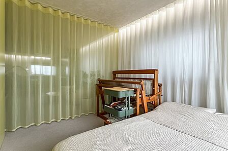 リビング中央のカーテンを閉めれば、ゆるやかに仕切られたベットルームとして使うことも可能。