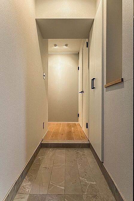 長尺タイルが目を惹く玄関。右手には下足入れのほかニッチがあり、正面の壁にはピクチャーレールが設置されています。
