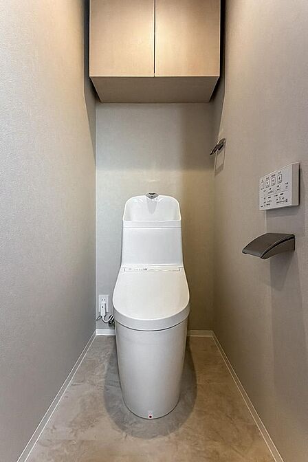 トイレには洗面室からアクセスする間取り。タオルハンガーやペーパーホルダーの金物が空間に品を添えます。
