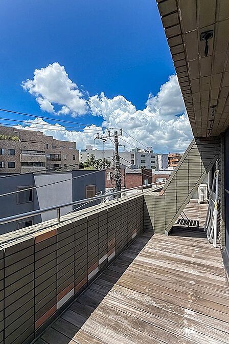 バルコニー/ウッドデッキが敷かれたバルコニーは、住戸と同じだけのワイドスパン。両端に花壇もあります。